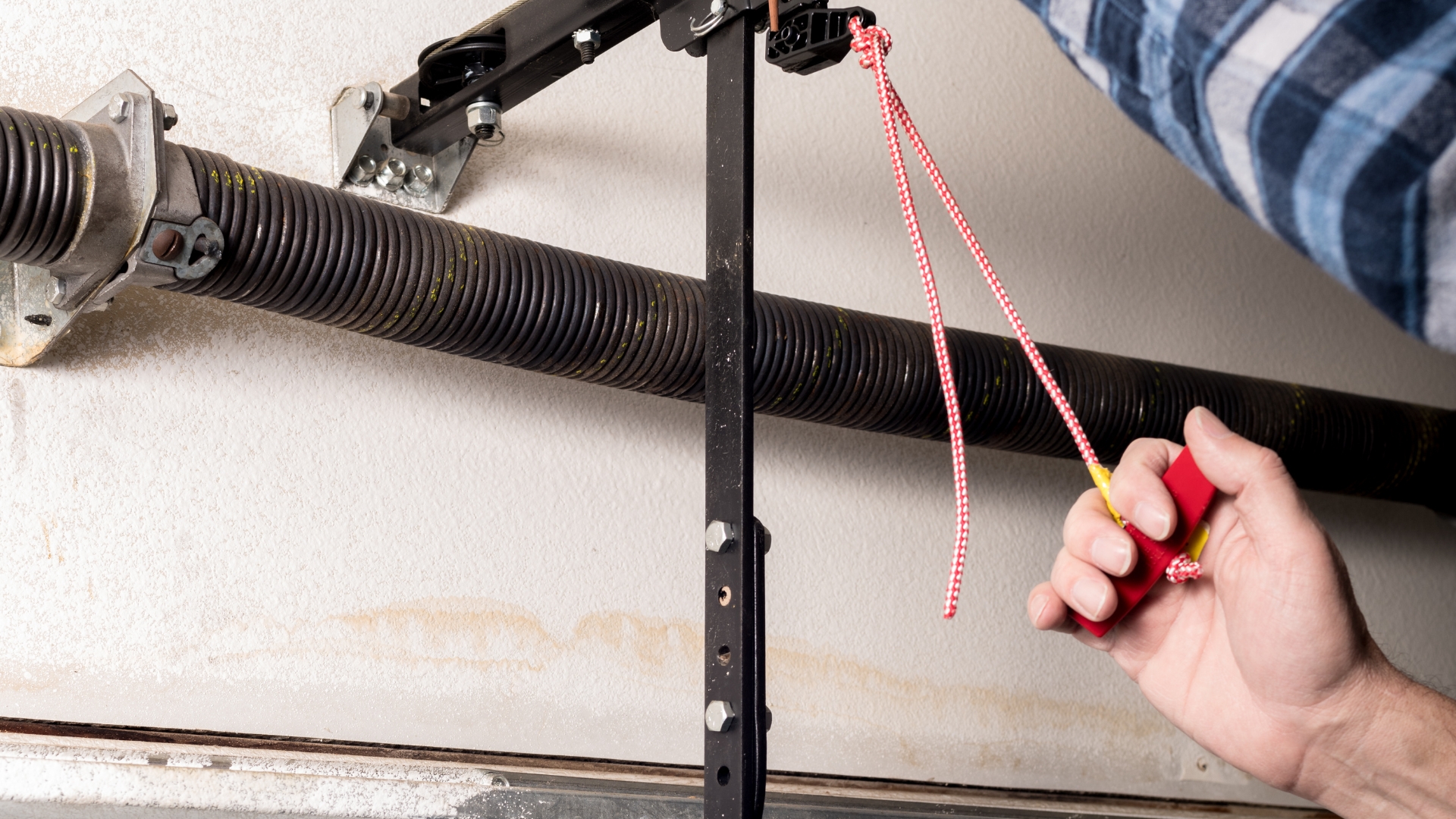 A garage door technician pulling the emergency release cord