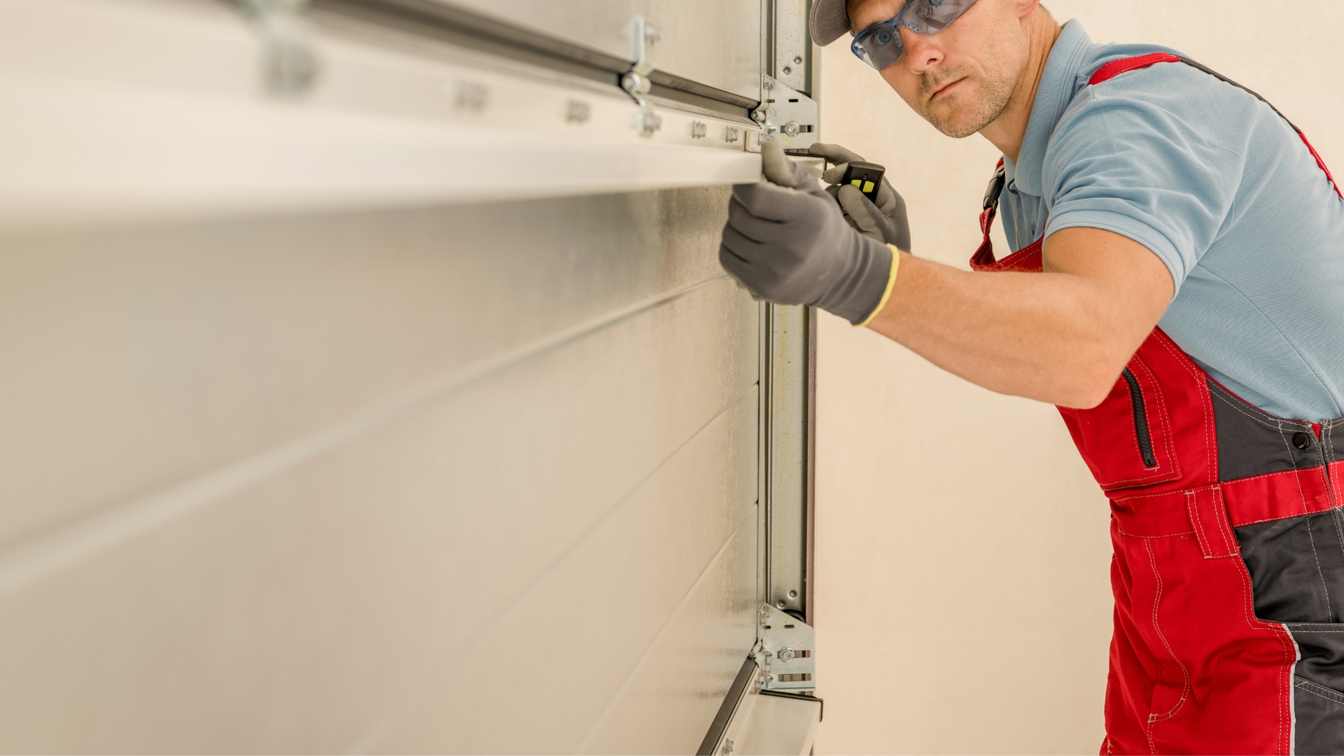 A technician inspects garage door rust during a maintenance check.