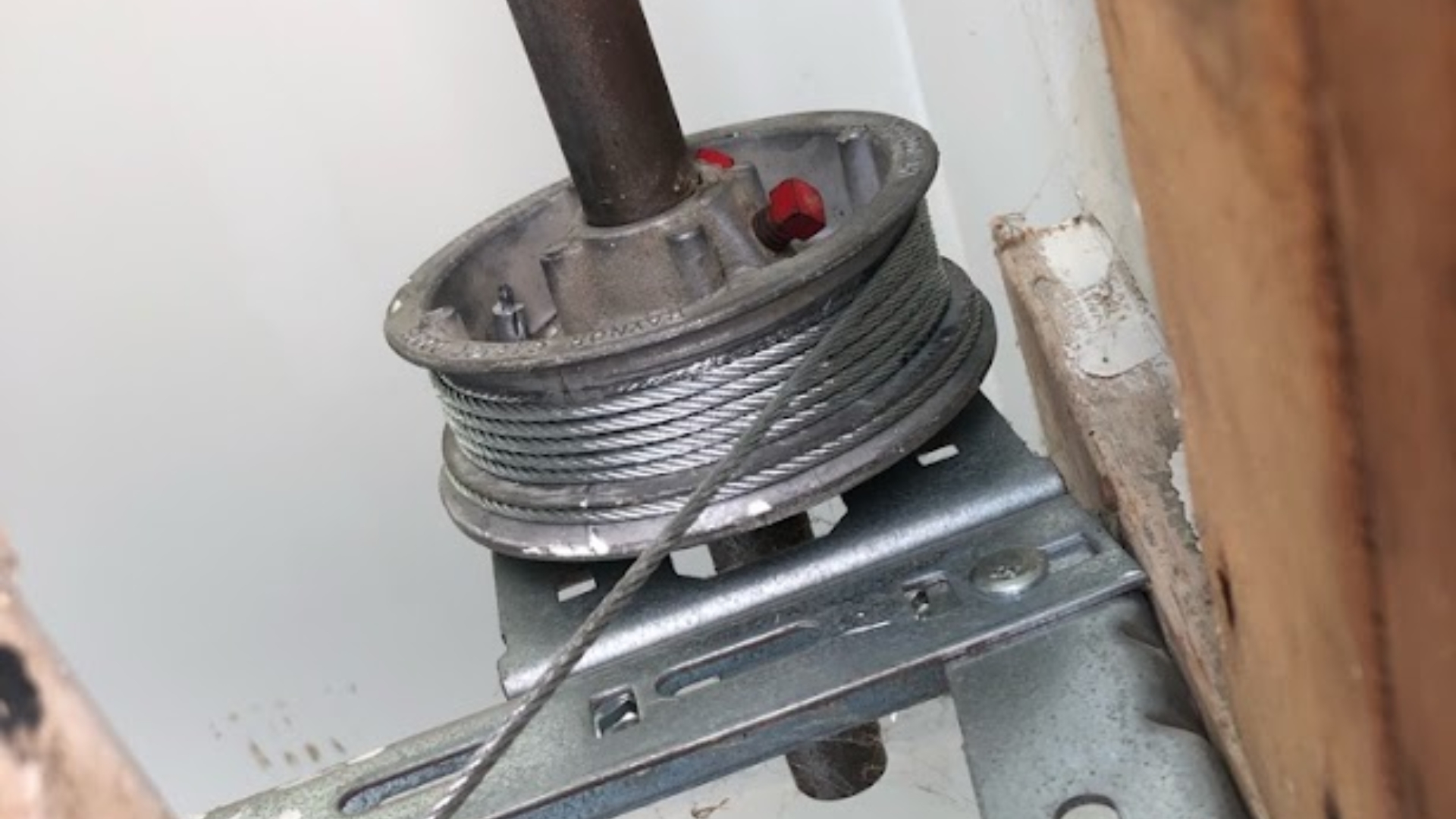 A garage door cable tightly wound around the drum mechanism